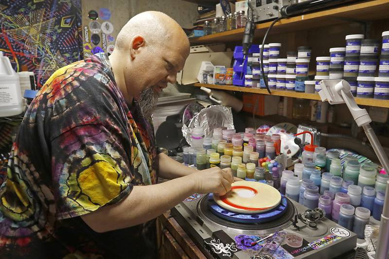 Mike Muggli makes one of his unique flying discs on Wednesday, May 22, 2024, at  his studios in his home in Crystal Lake.