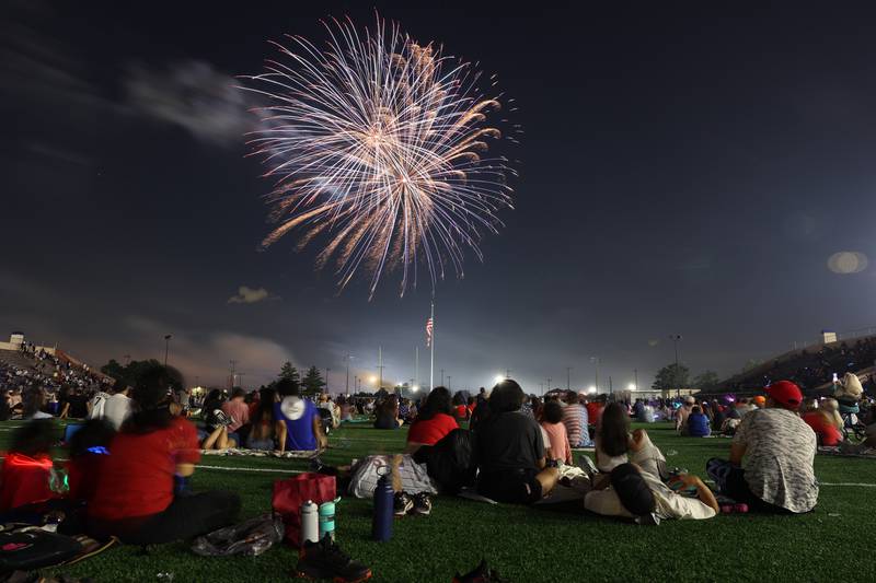 People watch the firework display from the field at Joliet Memorial Stadium in on Thursday July 4, 2024.