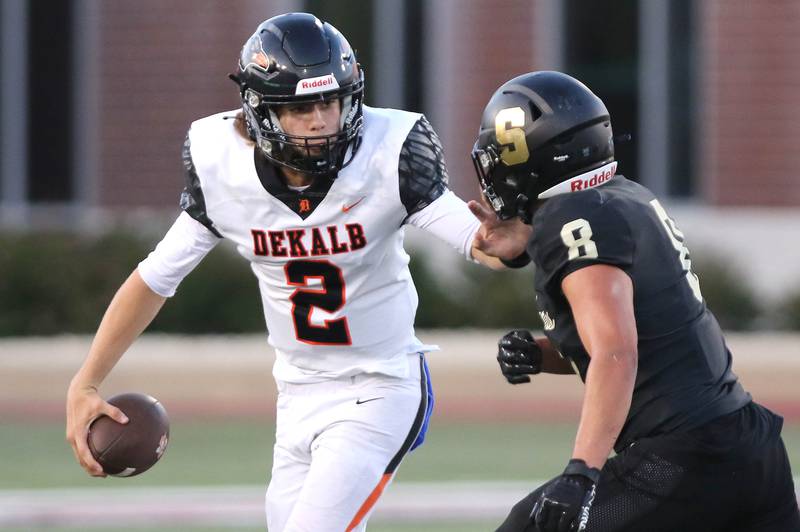 DeKalb's Cole Latimer tries to escape the pass rush of Sycamore's Diego Garcia during the First National Challenge game Friday, Aug. 25, 2023, in Huskie Stadium at Northern Illinois University in DeKalb.
