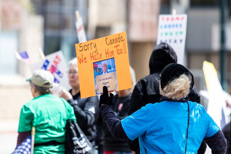 An attendee holds up a sign at the May Day Weekend Rally in Downtown Joliet on May 3, 2025.