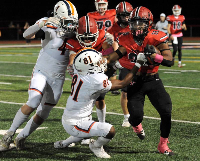 With blocking and tough running, Yorkville back Tavaris Harland, Jr (28) plows past several Oswego defenders for a long gain on Friday, Oct. 11, 2024, at Yorkville High School.