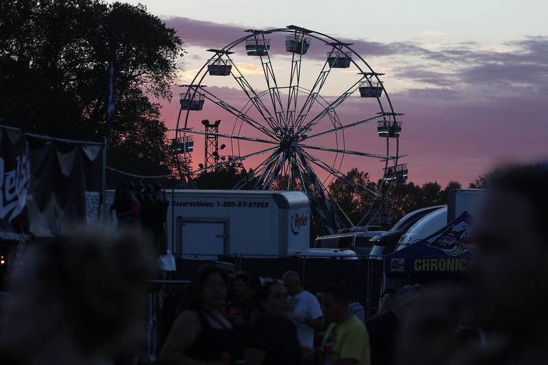 The sun sets as event goers ride the ferris wheel at Riot Fest on Saturday, Sept. 21, 2024 in Chicago.