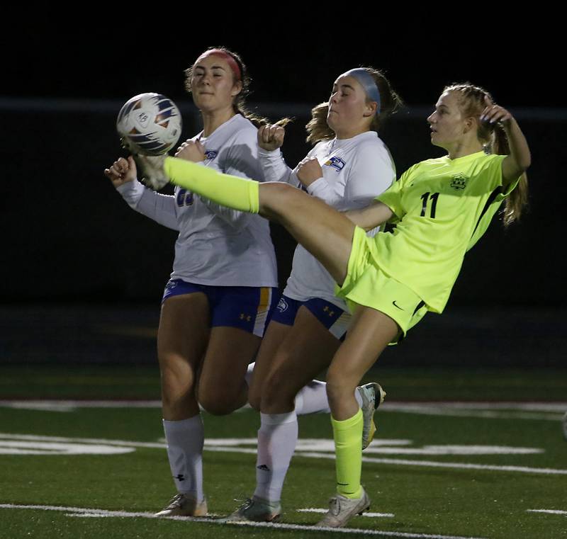 Richmond-Burton's Margaret Slove kicks the ball away from Johnsburg's Kiara Welch, (left)  and Jacquelyn Douglas during Kishwaukee River Conference Girls Soccer  Tournament Championship Match Wednesday, May 3, 2023, at Richmond-Burton High School.