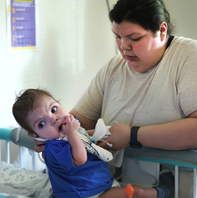 Kassandra Santos tends to her daughter Marely, 1, Monday, June 30, 2025, at their home in DeKalb. Marely was born with a myriad of health issues that require around-the-clock care and recently received a heart transplant.