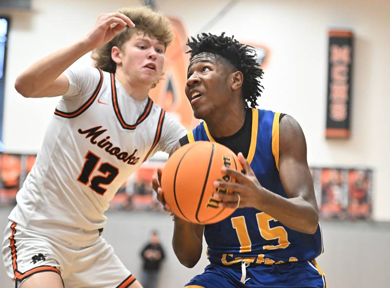 Joliet Central's James Lee (15) going strong to the basket against Minooka's Zane Caves (12) during a conference game on Friday, Jan. 10, 2025, at Minooka.