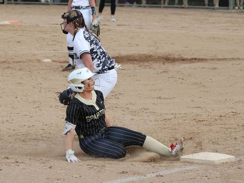 Sycamore's Addison McLaughlin slides in safely with a triple as Kaneland's Natalie Naab waits for the throw Tuesday, April 22, 2025, during their game at Sycamore High School.