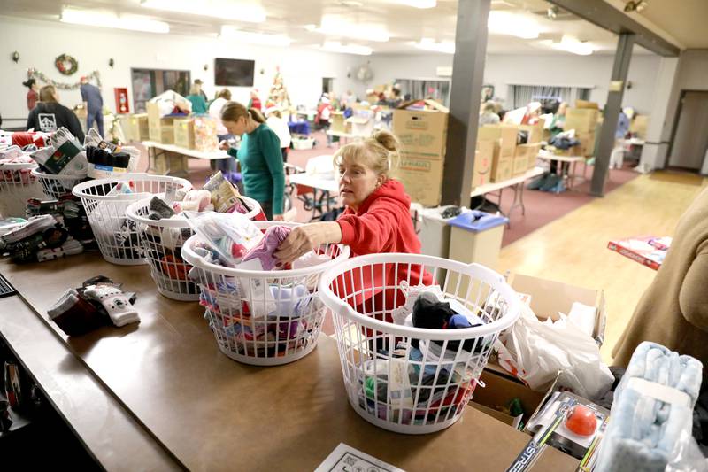 Volunteer Kari Edwards adds essentials to to be given to Batavia students in need as part of the Batavia United Way Adopt-A-Family program.