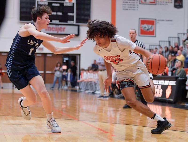 Wheaton Warrenville South's Braylen Meredith (25) drives around Lake Park's Camden Cerese (1) during a game on Saturday, Jan. 7, 2023.