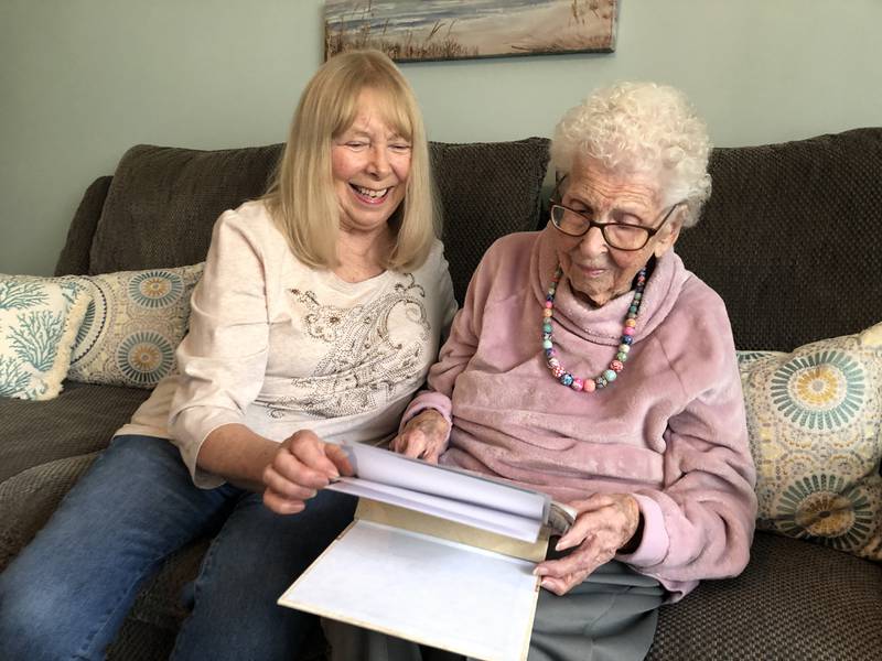 Kathy Cassidy and her mother, Genevieve "Genny" Hay, go through one of Hay's photo albums. Hay, seen here on Saturday, Nov. 5,  celebrated her 105th birthday on Thursday.