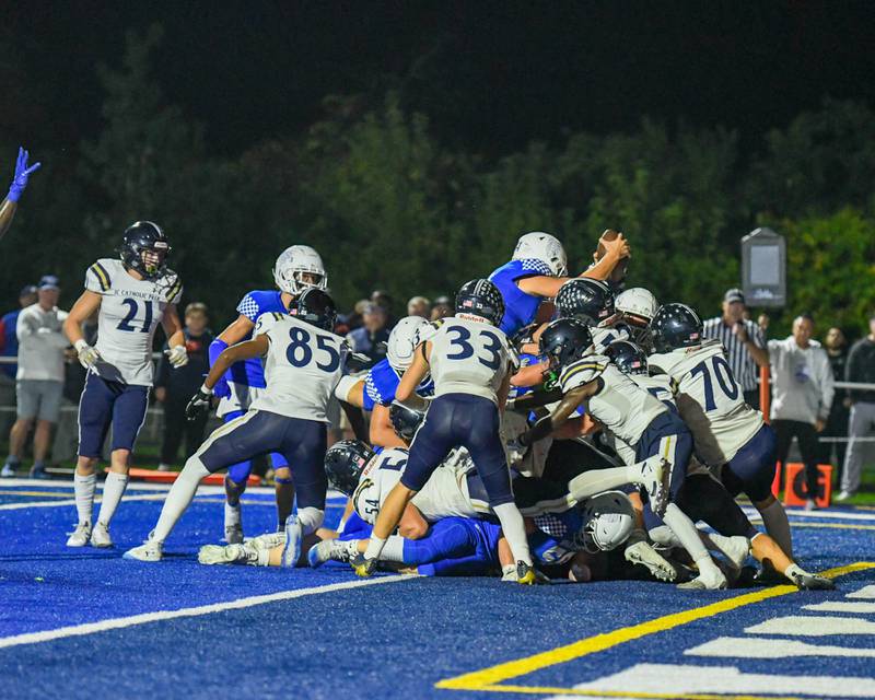 St. Francis Alessio Milivojevic, top, jumps over a mound of football players to score a touchdown while taking on IC Prep in the first quarter Friday Sep. 29, 2023, held at St. Francis in Wheaton.