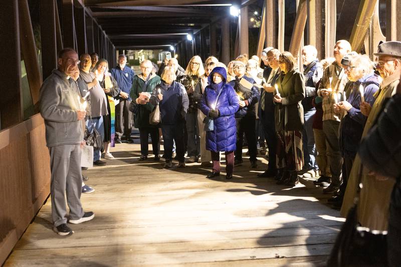 Locals gather for a candlelight vigil at the Peace on Earth Bridge as part of an International Peace Vigil with area faith leaders on Sunday, Nov.23, 2025, in Batavia.