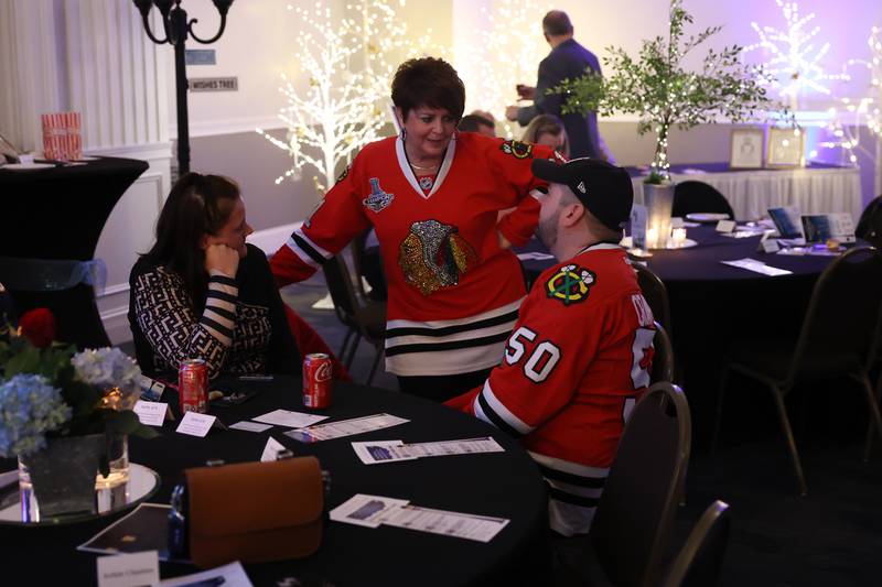 Celeste Bessette (center) talks with Hillary and Taylor Serena at the Shorewood HUGS "Sweet Home Chicago" chocolate ball fundraiser in Joliet on Saturday, February 4, 2023.