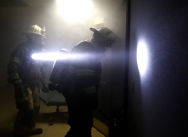 Algonquin firefighters from RIT team one  enter a smoke filled basement as they search for an injured firefighter on Tuesday April 15, 2025, during a RIT crew and chief divisional drill with other firefighters from area departments in a former bank building in Downtown McHenry.