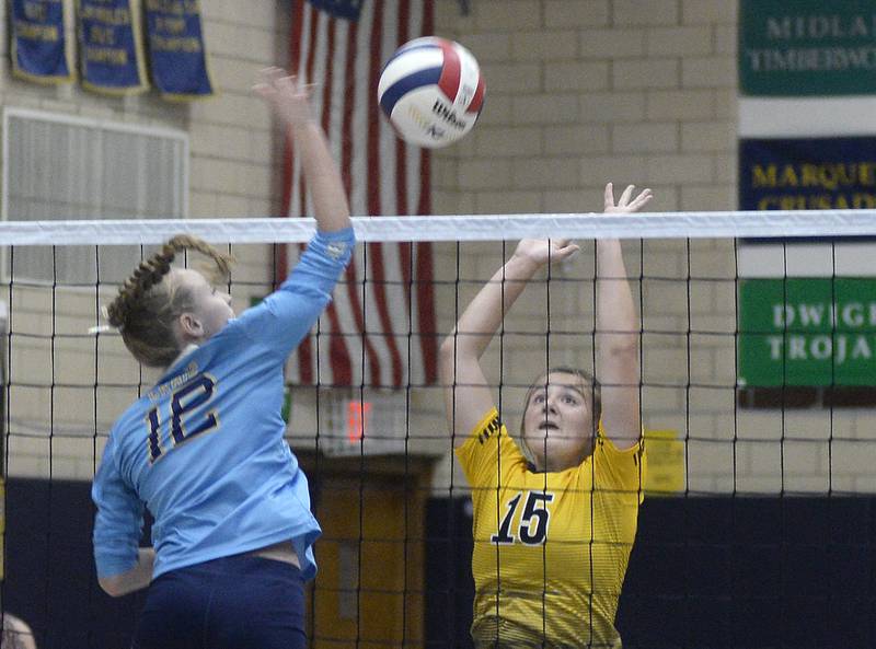 Marquette’s Lily Craig works to get the ball past a block attempt by Reed Custer’s Kara Steffes during the first match Monday at Marquette.