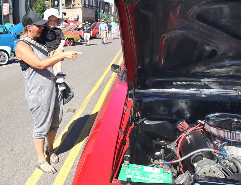 Beau Willrett, 1, from Malta, gets a lift from his aunt Heidi Carlson, from Sycamore, as they check out one of the cars on State Street in Sycamore Sunday, July 31, 2022, during the 22nd Annual Fizz Ehrler Memorial Car Show.