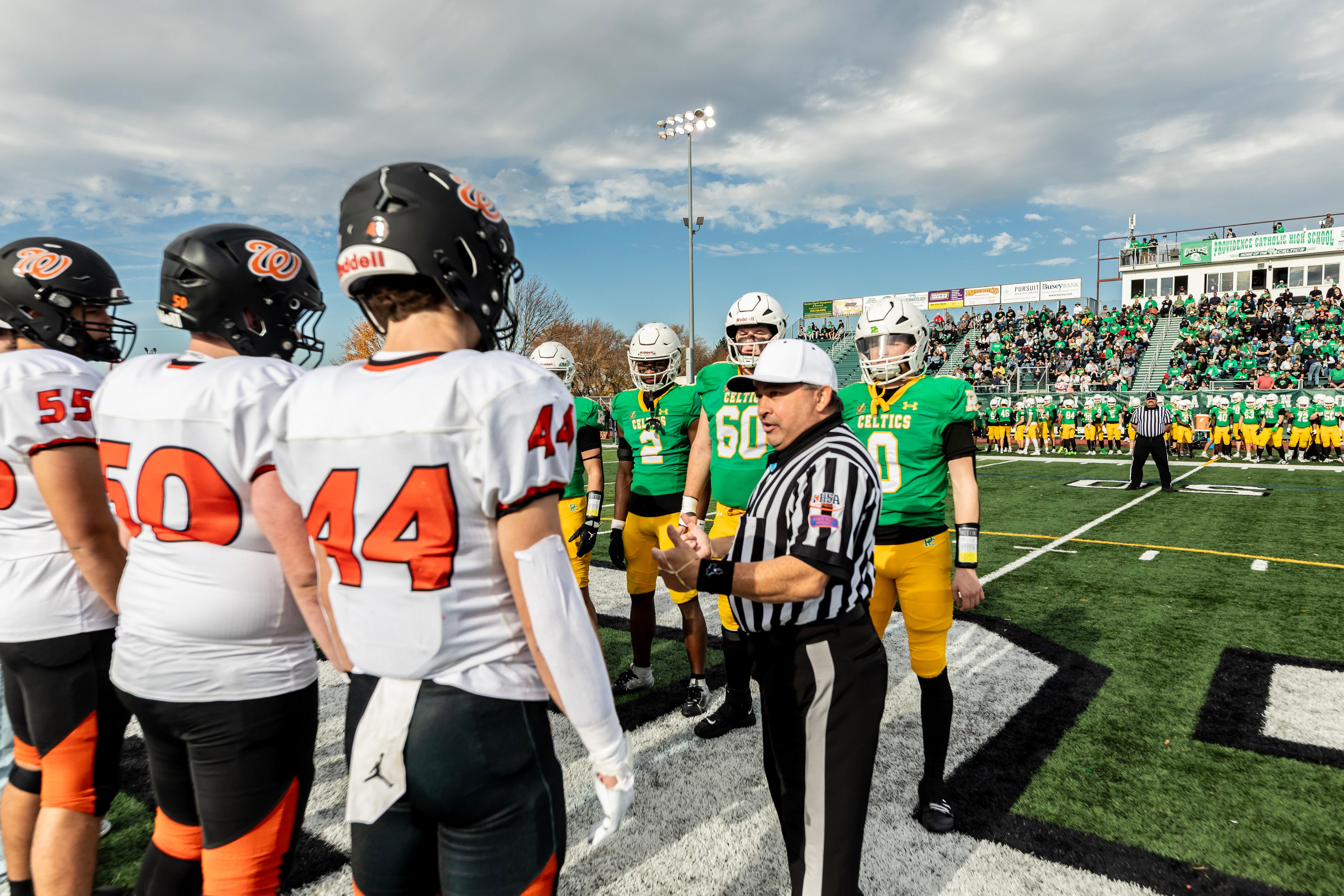 The captains from Providence and Washington meet at the 50-yard-line for the coin toss prior to a 5A varsity football playoff game at Providence on Nov. 15, 2025.