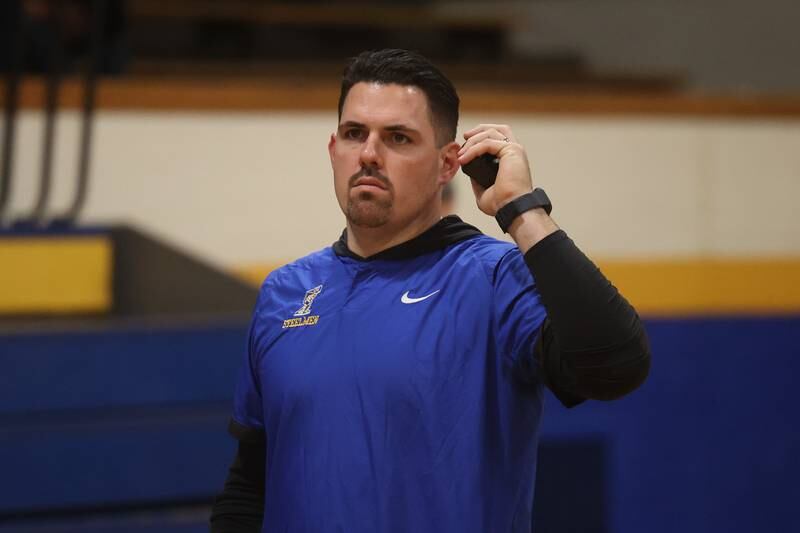 Joliet Central athletic director Jon Pereiro monitors the radio after the game against Joliet West.