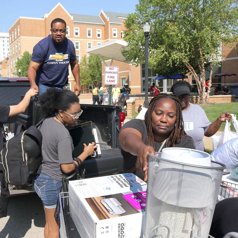 Northern Illinois University junior Krista Cooper, (left) from Monee, gets a hand from her family as they load up carts with things to move into her room Wednesday, Aug. 23, 2023, during move-in day in front of the Fanny Ruth Patterson Complex at NIU in DeKalb.