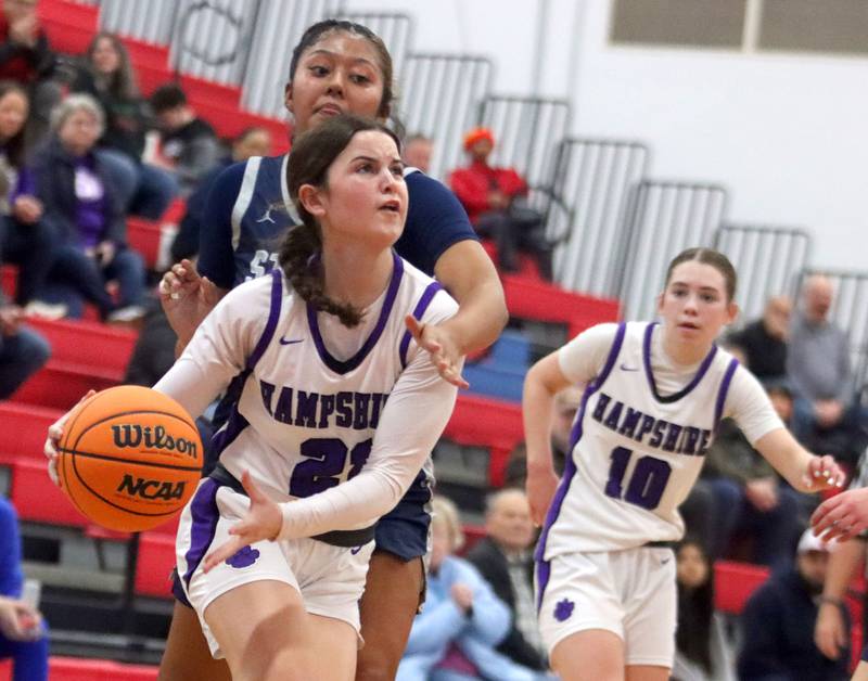 Hampshire’s Veronica Dumoulin scoots past South Elgin’s Janessa Price in varsity girls basketball Komaromy Classic tournament  action on Monday, Dec. 29, 2025, at Dundee-Crown High School in Carpentersville.