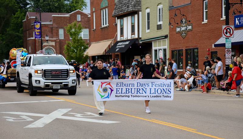 Representatives from the Elburn Leos march with the Elburn Lions Club banner in the annual Elburn Days Parade on Friday, Aug. 16, 2024.