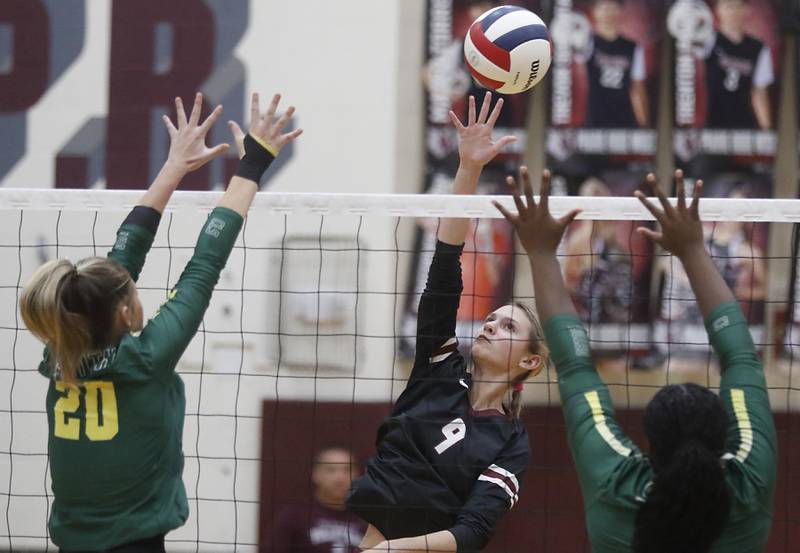 Prairie Ridge's Harleigh Serpico (center) hits the ball between the block of Crystal Lake South's Bobbi Wire (left) and Sahara Okirika (right) during the IHSA Class 3A Prairie Ridge Regional championship volleyball match on Thursday, Oct. 30, 2025, at the Prairie Ridge High School in Crystal Lake.