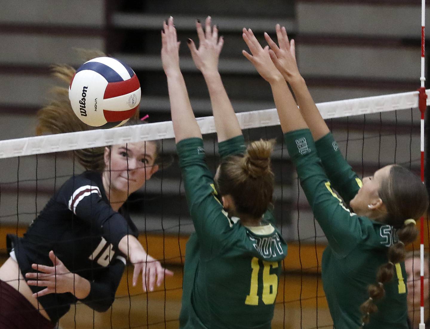 Prairie Ridge's Addy Grider (left) hits the ball past the block of Crystal Lake South's Sedona Semradek (center) and Nora Wiggs (right) during the IHSA Class 3A Prairie Ridge Regional championship volleyball match on Thursday, Oct. 30, 2025, at the Prairie Ridge High School in Crystal Lake.