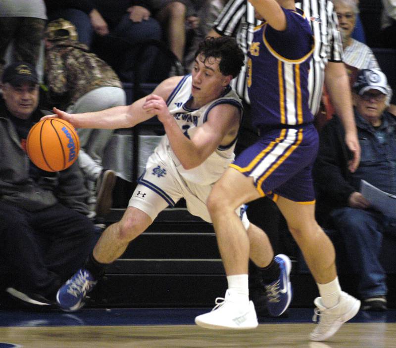 Newman's Garret Matzick drives around a Mendota defender. The 18-0 Newman Comets defeated  the 14-4 Mendota Trojans 67-66 at Newman High School. The game took place on Tuesday, January 13, 2025.