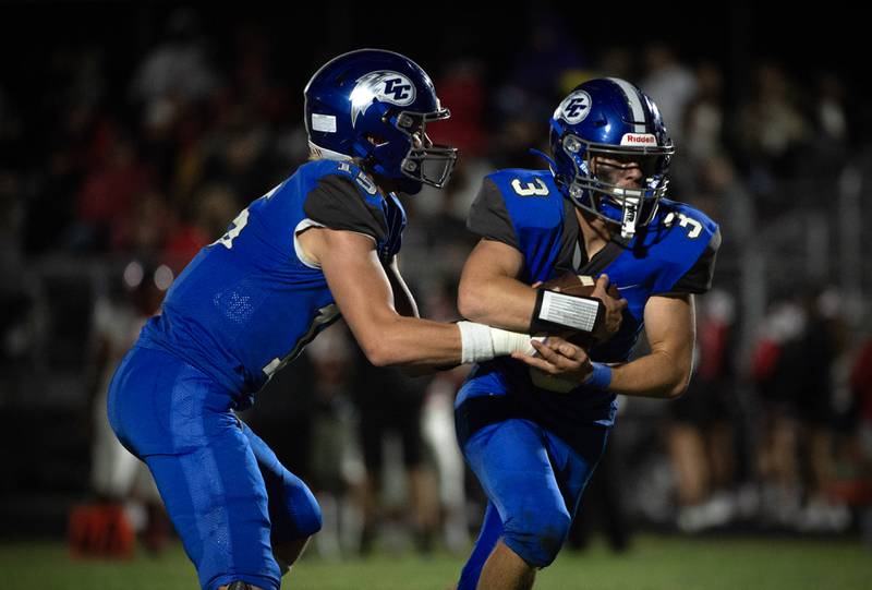 Clifton Central's Brady Shule, left, looks to hand off to Evan Cox in a game against Momence on Friday, September 5, 2025.