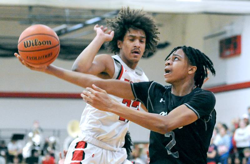 Oswego East's Mason Lockett IV (2) attempts a reverse layup against Yorkville defender Jory Boley during a February 2024 varsity basketball game at Yorkville High School.