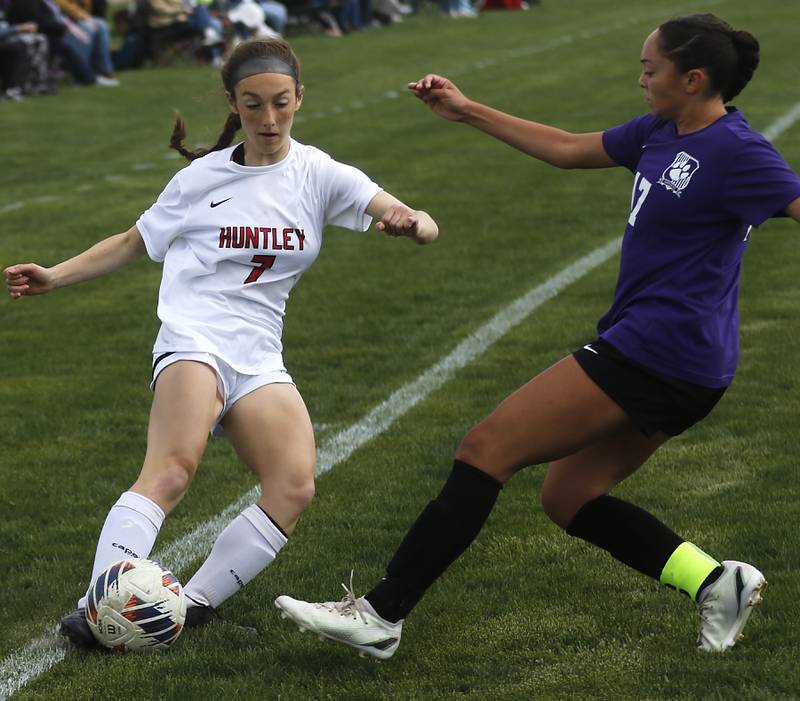 Huntley's Kate Sandora kicks the ball as she is defended by Hampshire's Helen Negron during a Fox Valley Conference soccer game on Tuesday, April 23, 2024, at Hampshire High School.