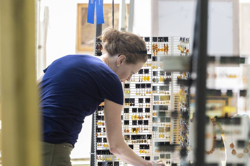 Sarah Saionz of Fulton looks over Baltic Amber jewelry by artist Malgorzata Rogowski Sunday, Sept. 7, 2025, at the Grand Detour Arts Festival.