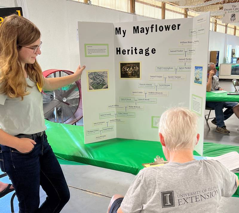 4-H’er Jenna Green of Oswego presents her family heritage project to volunteer Anne Sears of Plano during Kendall County 4-H conference judging at the county fairgrounds in Yorkville.