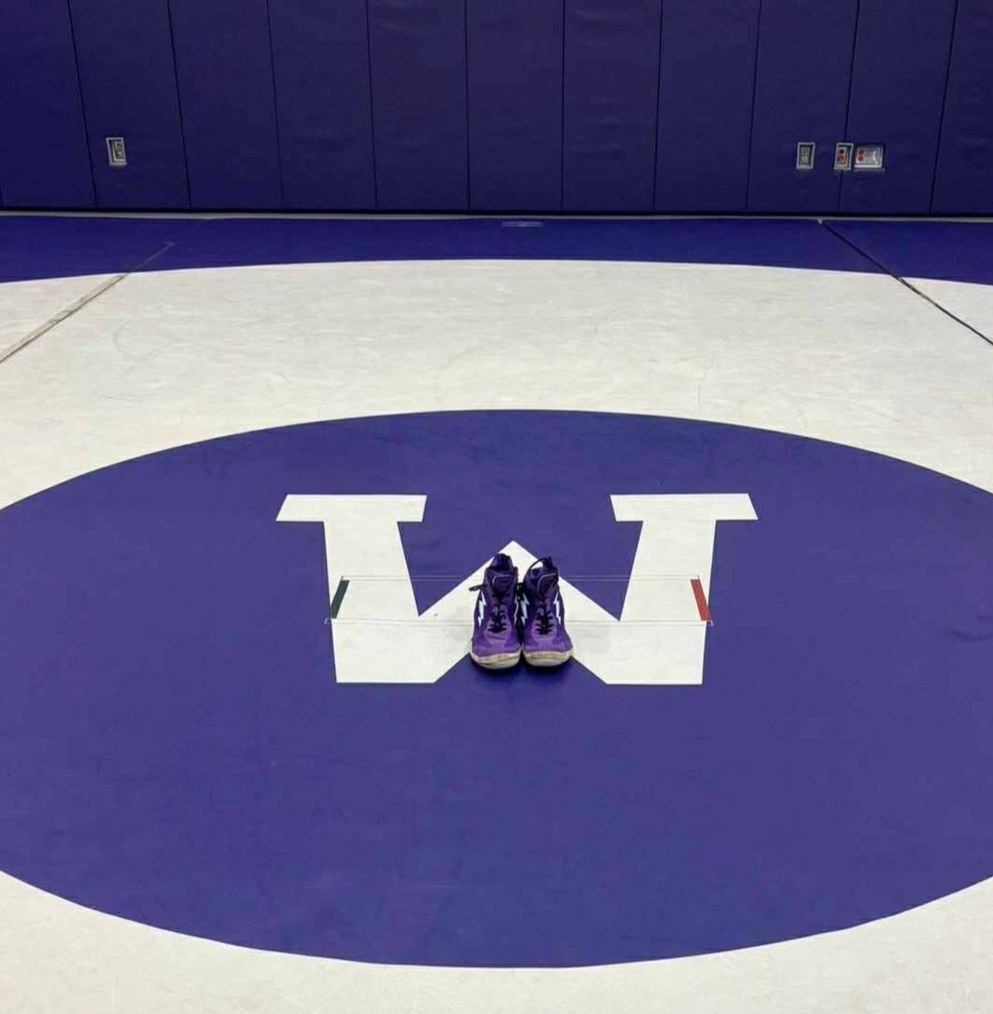 The wrestling shoes belonging to the late Wilmington wrestling coach Nick Dziuban are shown on the mat at Wilmington High School in this image provided by Wildcat wrestler Devin Findlay. Teammates gathered to remember their late coach on Feb. 3, 2026, tossing his shoes into the rafters of the wrestling practice gym where they will remain in his honor.