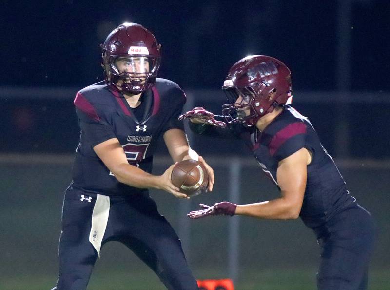 Marengo’s Gavin Baros, right, grabs a handoff from Sam Vandello against Johnsburg in varsity football at Rod Poppe Field on the campus of Marengo High School in Marengo on Friday, Oct. 3, 2025.