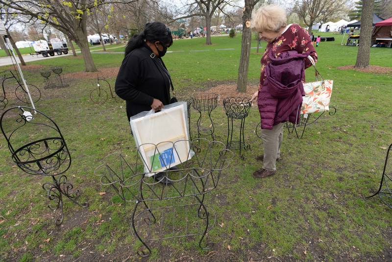 (left) Nancy Perry of Glendale Heights and Susan DalPorto of Roselle show interest in plant holders during the Elmhurst Art Festival Saturday April 30, 2022.