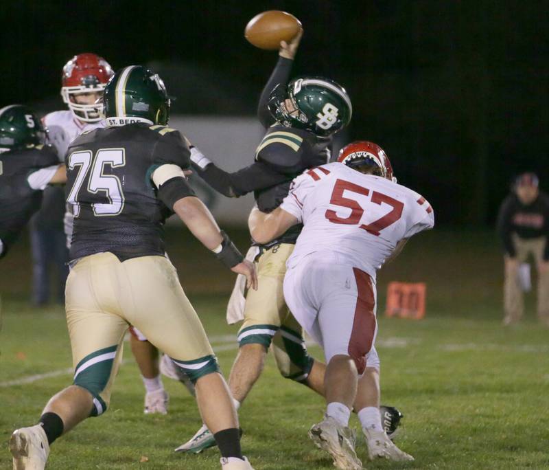 Hall's Joel Koch (57) hits St. Bede quarterback John Brady as he is about to throw a pass on Saturday, Oct. 15, 2022 at the Academy in Peru.