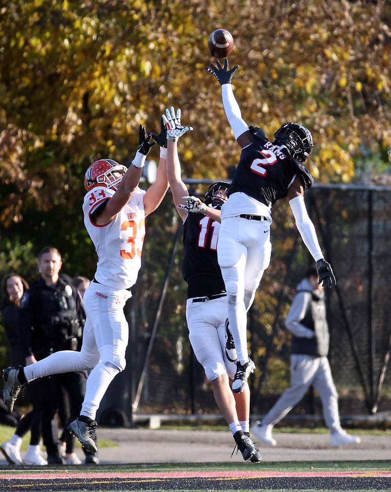 Glenbard East's Quami Stanton (2) and Aaron Dotson (11) knock down a pass intended for Normal's MarÕQuan Gary (3) during the IHSA Class 7A quarterfinals Saturday November 11, 2023 in Lombard.