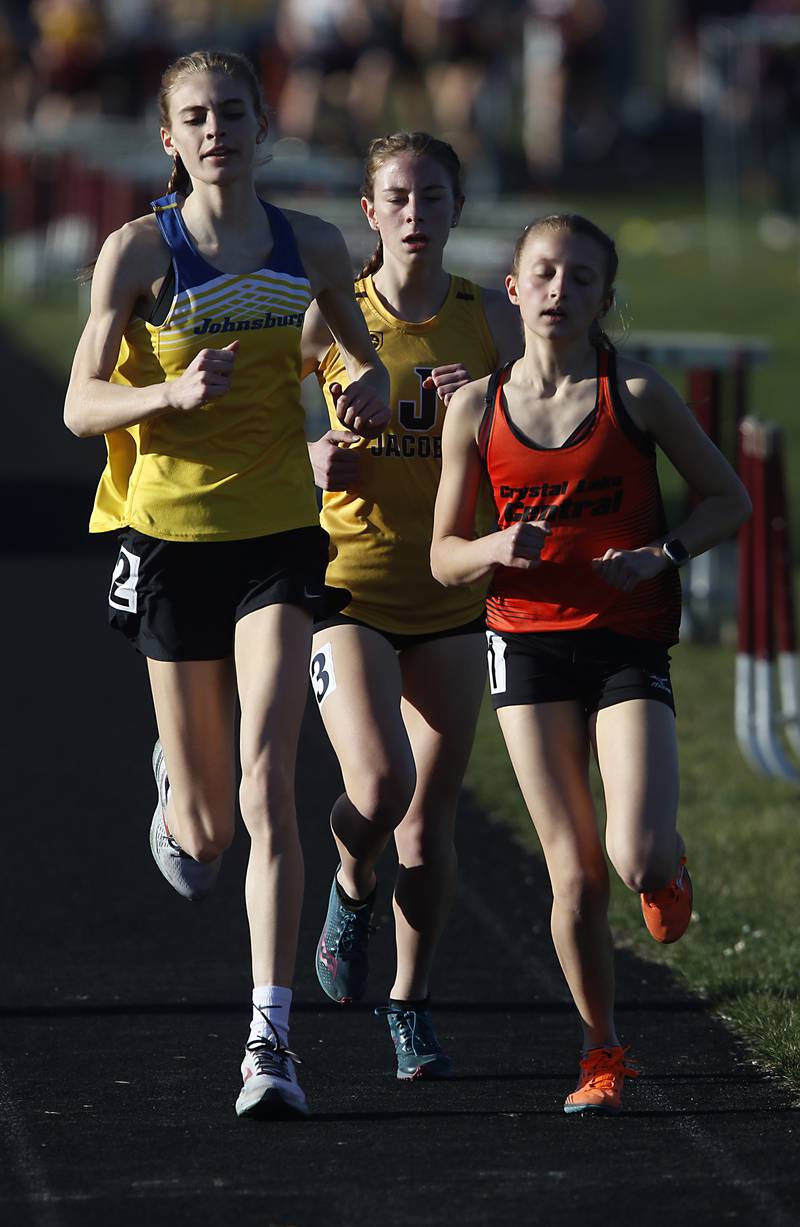 Johnsburg’s Jolene Cashmore, Jacobs’s Bailey Schwartz and Crystal Lake Central’s Brynn Matthaei run the 3200 meter run Thursday, April 21, 2022, during the McHenry County Track and Field Meet at Richmond-Burton High School.