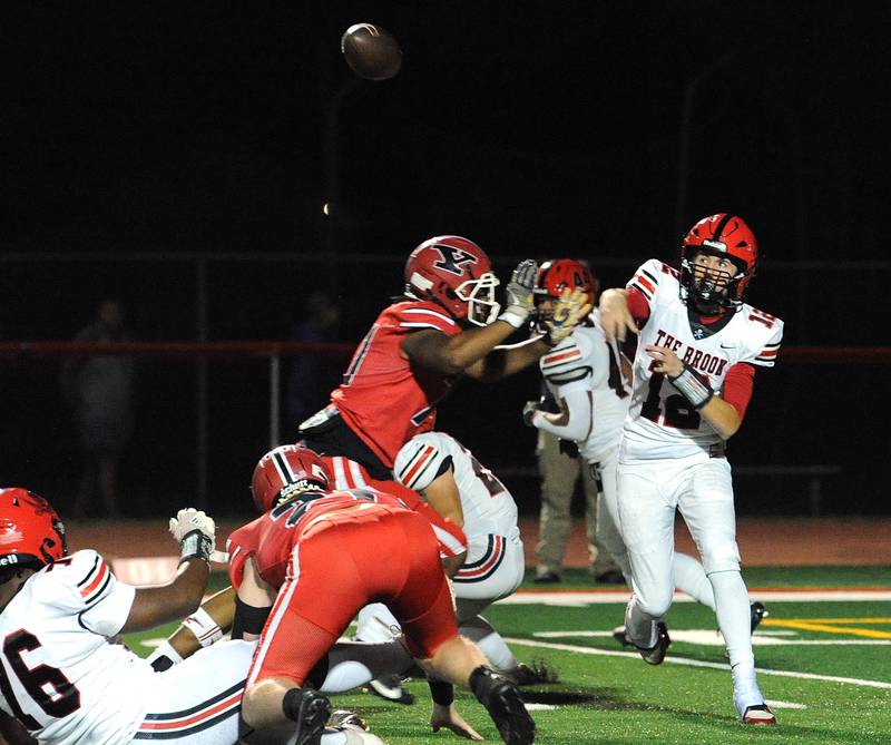 Bolingbrook quarterback Braden Anderson (12) throws a pass under pressure from a Yorkville defender on Friday, Sept. 27, 2024, during a varsity game at Yorkville High School.