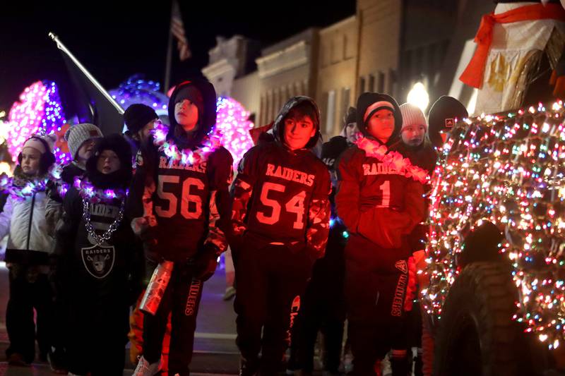 Football players march during the Festival of Lights Holiday Parade in downtown Crystal Lake on Friday, Nov. 29, 2024.