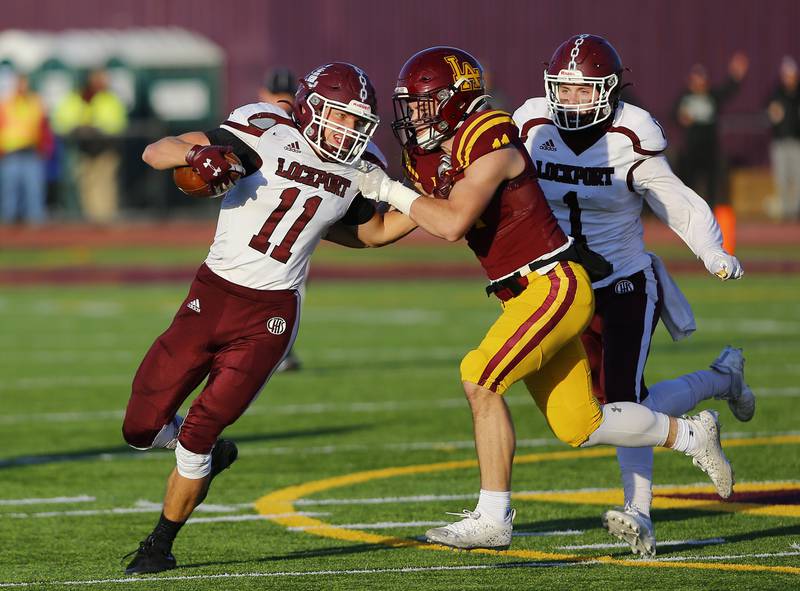 Lockport's Dylan Schumutzler (11) is tracked down by Loyola during the IHSA Class 8A varsity football semifinal playoff game between Lockport Township and Loyola Academy on Saturday, November 20, 2021 in Wilmette.