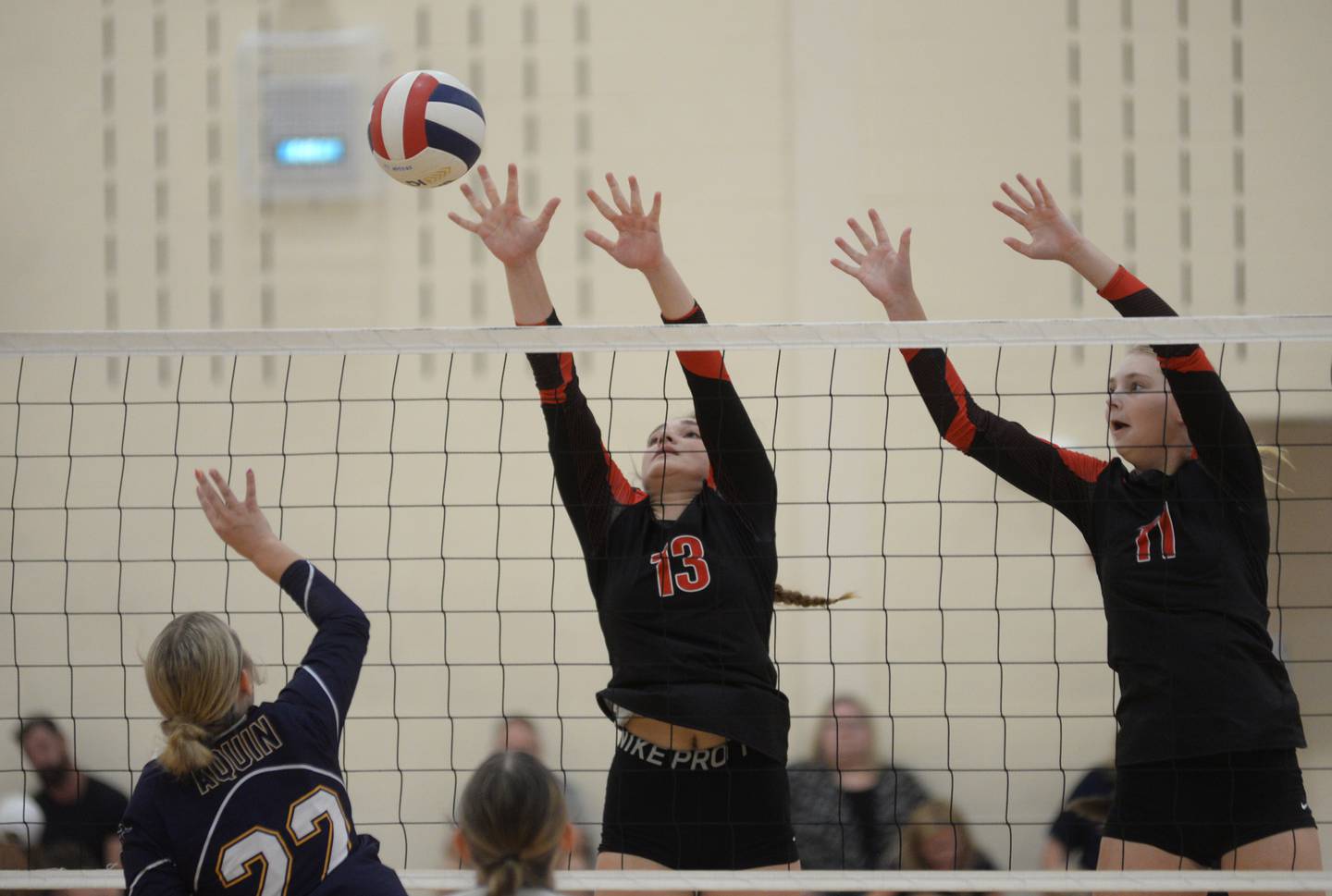 Erie-Prophetstown's Kennedy Buck (13) and Lauren Abbott (11) reach to try and block a spike by Freeport Aquin's Meghan Carlisle during the Oregon High School's 2023 Volleyball Tournament on Friday, Sept. 1, 2023 at the Blackhawk Center in Oregon.