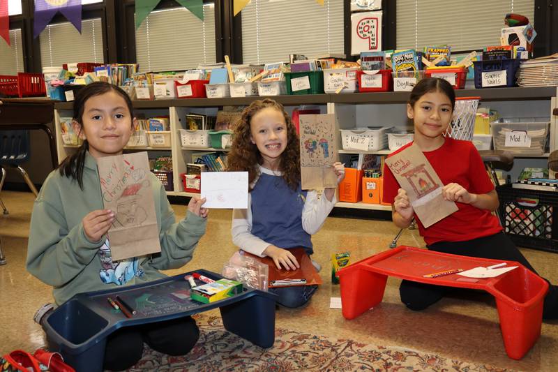 Fourth graders America Ornelas, Grace Boykin, and Jessica Diazdeleon with their bags they personalized with drawings and kind words for people at MorningStar Mission.