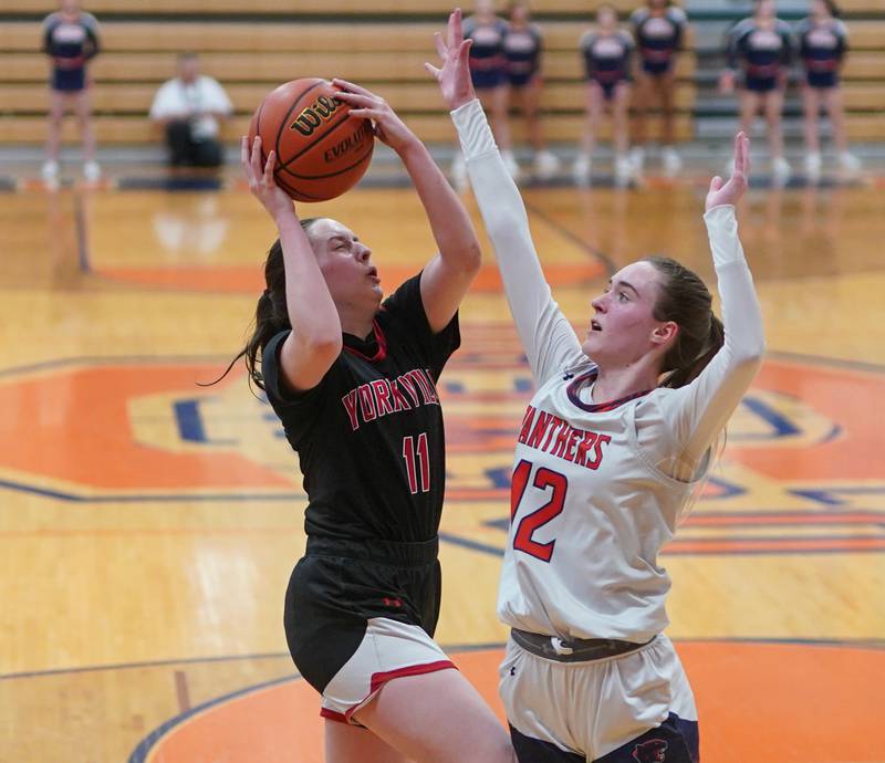 Yorkville's Brooke Spychalski (11) drives to the hoop against Oswego’s Emily Mengerink (12) during a basketball game at Oswego High School on Saturday, Jan 27, 2024.