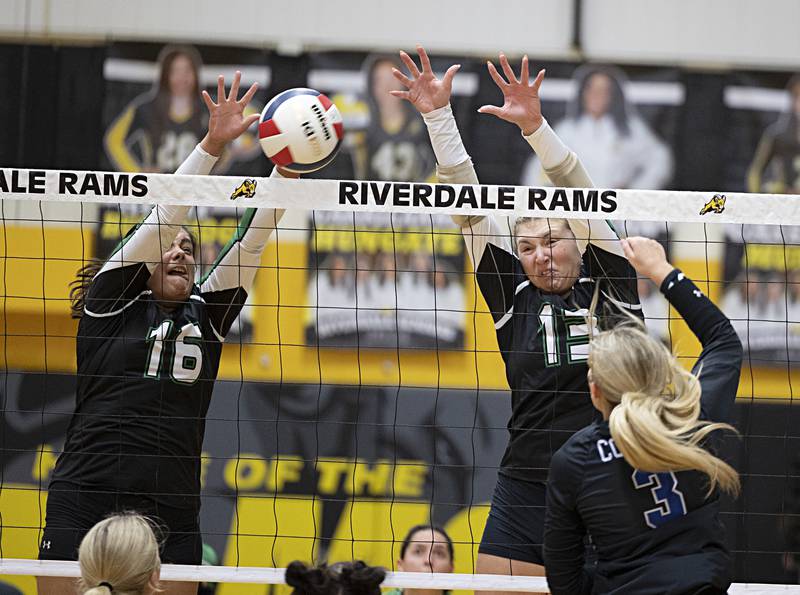 Rock Falls’ Taylor Reyna (left) and Claire Bicket go up for a block against Newman Thursday, Oct. 26, 2023 in the class 2A regional finals at Riverdale.