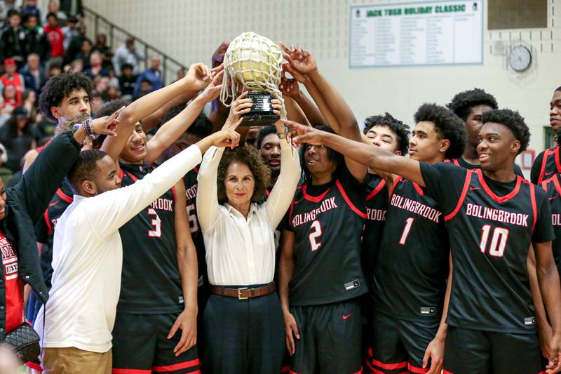Bolingbrook poses with Jack Tosh's daughter lisa with the championshiip trophy after winning their Jack Tosh Holiday Classic basketball tournament Championship game between Fenwick at Bolingbrook. Tuesday Dec 31, 2024 in Elmhurst.