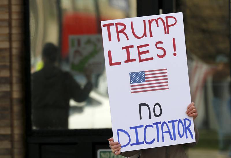 Protesters line U.S. Route 12 in Richmond to protest their discontent with President Donald Trump and his administration's policies on Saturday, April 19, 2025. Over 100, people took part in the Richmond protest. A second rally was held in Harvard later in the day.