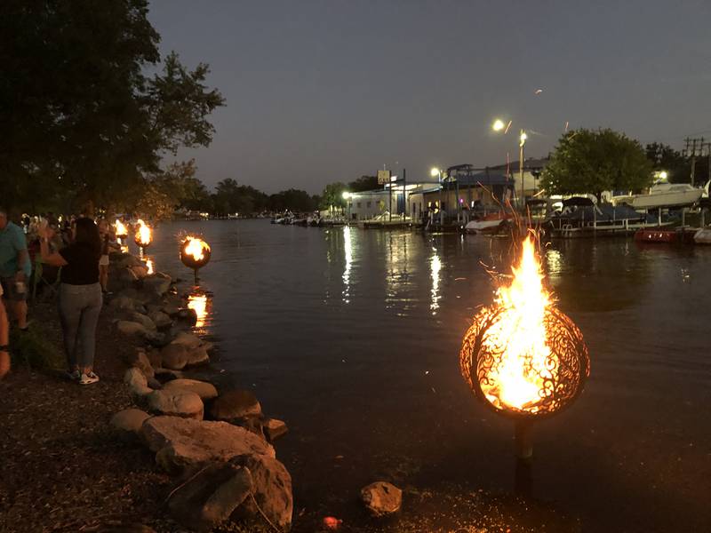 Boats pulled into docks or floated past McHenry's Miller Point Park on Saturday, Sept. 27, 2025, on their way to one of the downtown restaurants during the annual Light the Night. The city lights fires in the 15 fire globes lining the Riverwalk,