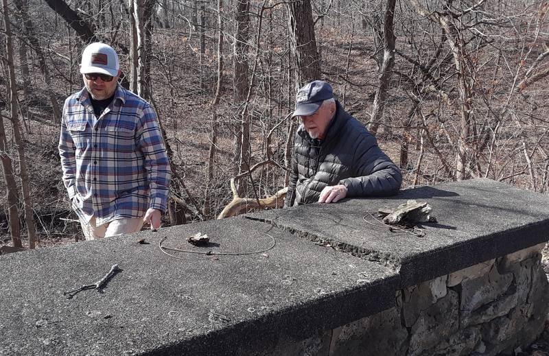 Chuck Sanders, president of the Wallace-Dickey Cemetery Preservation Association, and Keith Stehl (left), Ottawa Masonry, look at the current condition of the wall surrounding the Wallace-Dickey Cemetery, a land-locked private family cemetery, on the North Bluff in Ottawa.