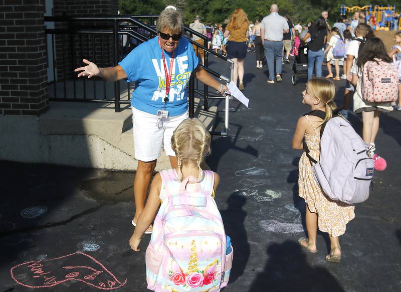 Teacher Patricia Carter greets students as the arrive for the first day of school at West Elementary School in Crystal Lake on Wednesday, Aug. 16, 2023.